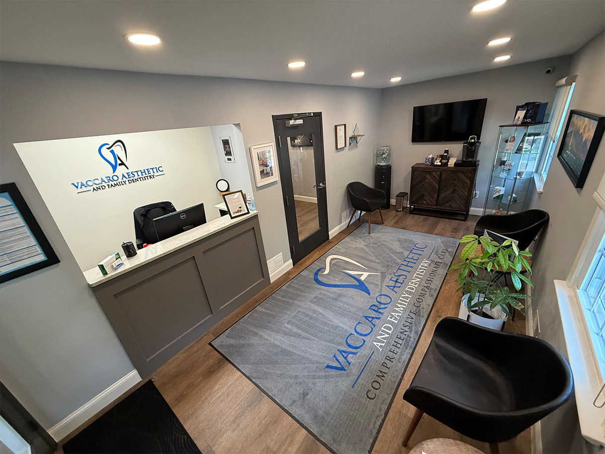 The image displays an interior view of a dental office reception area with a modern design, featuring a waiting room, a receptionist s desk, and a sign with the name  WACOAN DENTAL .