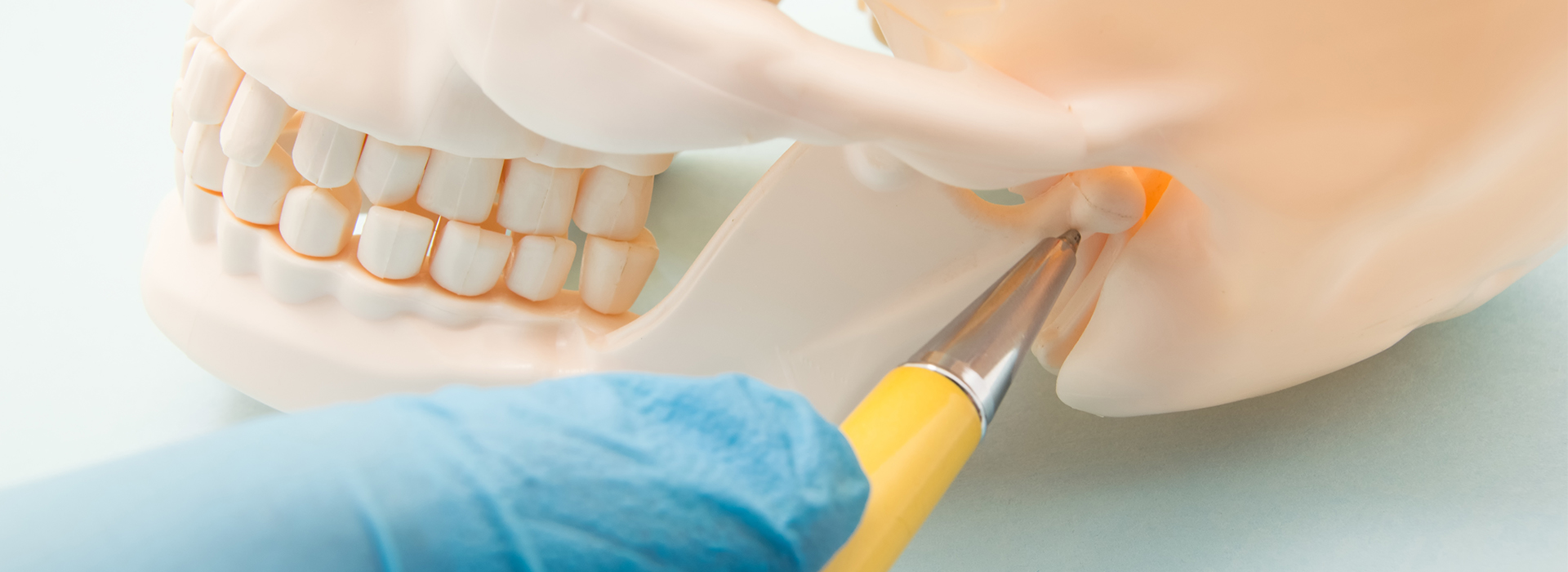 The image shows a close-up view of a dental implant procedure with a hand holding a screwdriver over a patient s mouth, where a tooth is being prepared for an implant.
